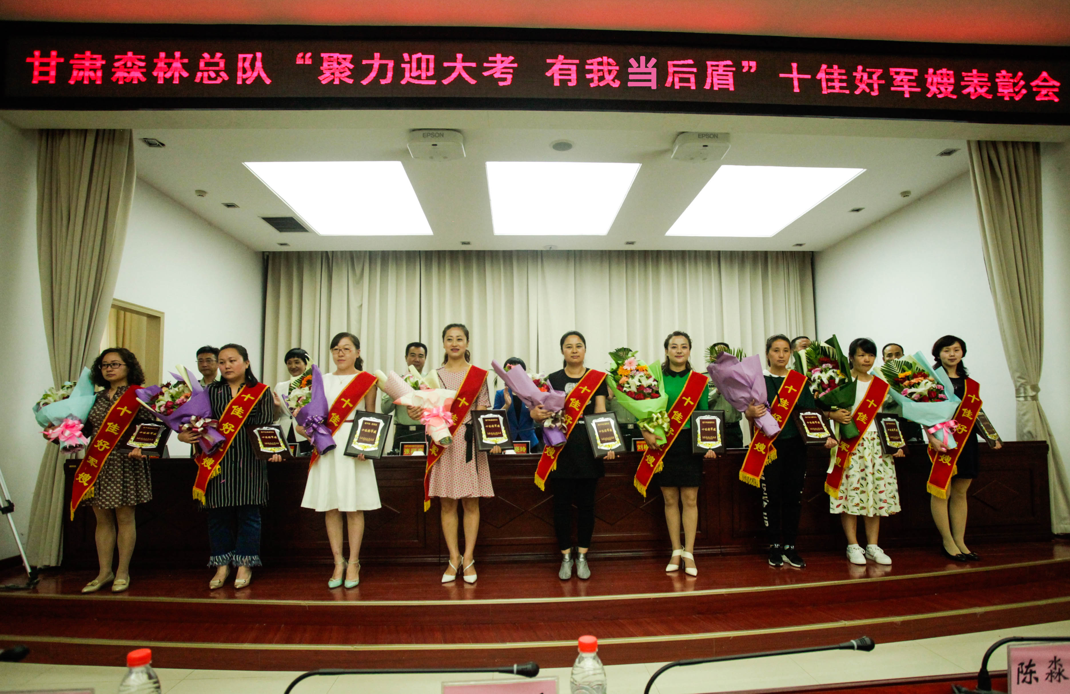 图1：受表彰的10名好军嫂只有9名来到了大会现场，该总队直工科长常利的爱人孙毓英远在安徽怀远一所中学任教，她带的学生们即将高考了，为了不影响孩子们，孙毓英最终遗憾缺席。.jpg